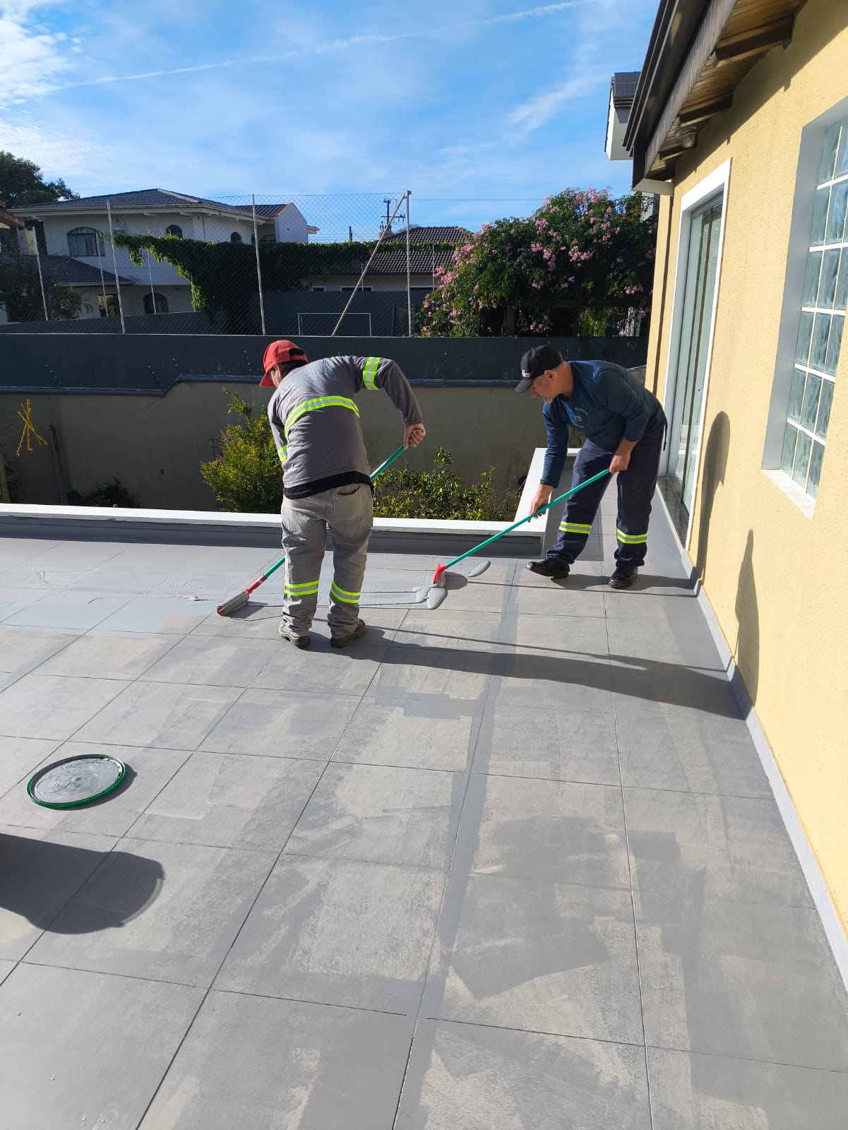 Funcionários da AR4 aplicando impermeabilização em telhado